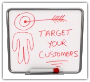 A white dry erase board with red marker, with the words Target Your Customers