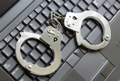 Handcuffs on keyboard, courtesy of Shutterstock