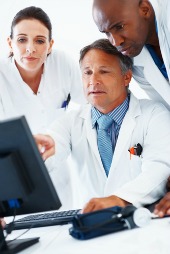 Doctors around computer, courtesy of Shutterstock