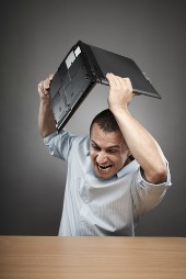 Man breaking computer, courtesy of Shutterstock