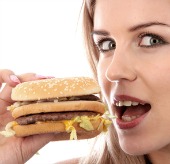 Woman eating burger, courtesy of Shutterstock