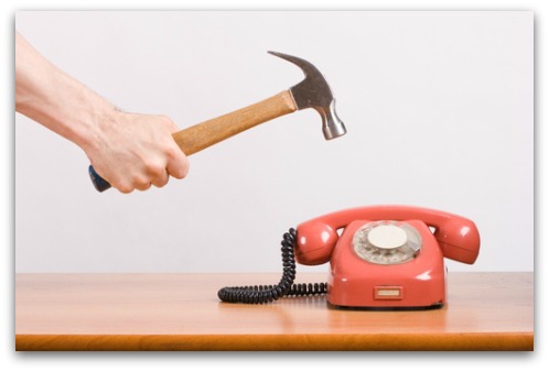 Smashing telephone with hammer. Image from Shutterstock