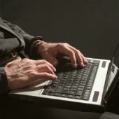 Man on computer. Image courtesy of Shutterstock