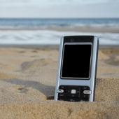 Phone in sand. Image courtesy of Shutterstock.