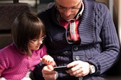 Image of child and father with phone courtesy of Shutterstock