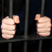 Man behind bars. Image courtesy of Shutterstock. 