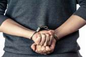 Image of jailed man courtesy of Shutterstock