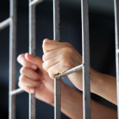 Image of man in jail courtesy of Shutterstock