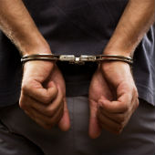 Image of handcuffed man, courtesy of Shutterstock